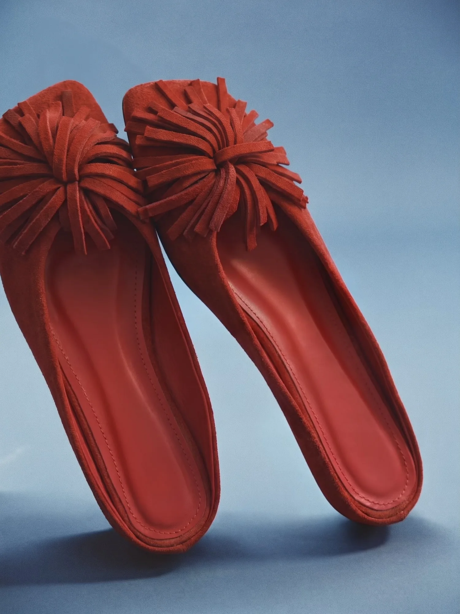 Still life ürün görseli — mavi fonda kırmızı terlik