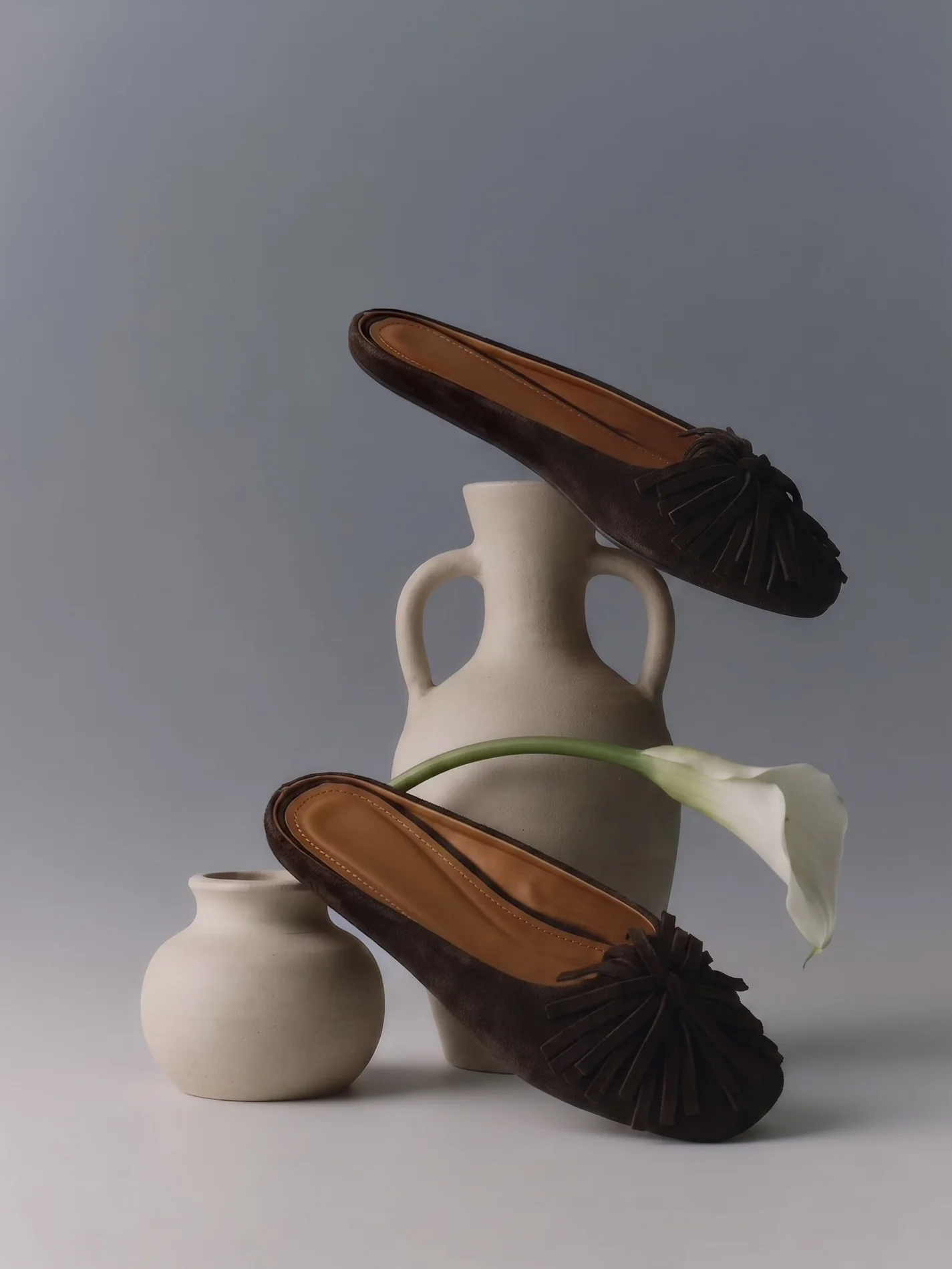 Still life ürün görseli — seramik objelerle siyah ayakkabı